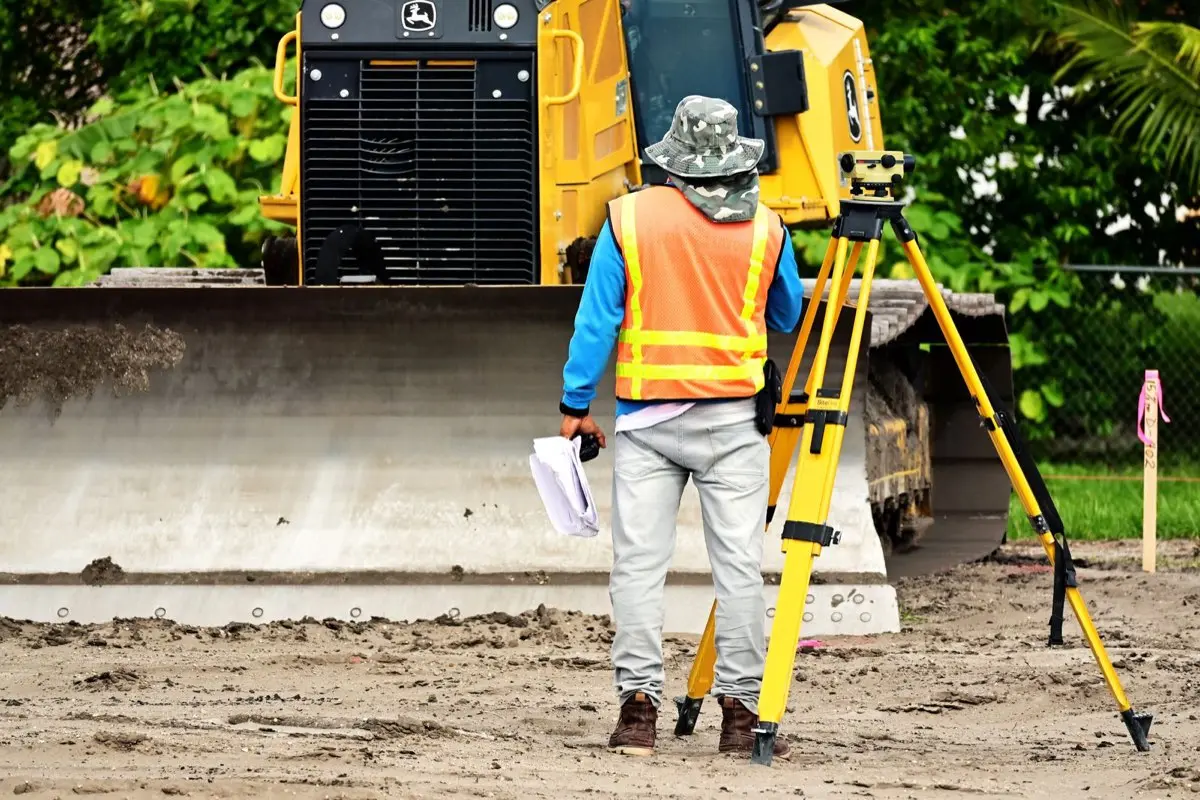 Arpenteur relevant des mesures de terrain sur un chantier