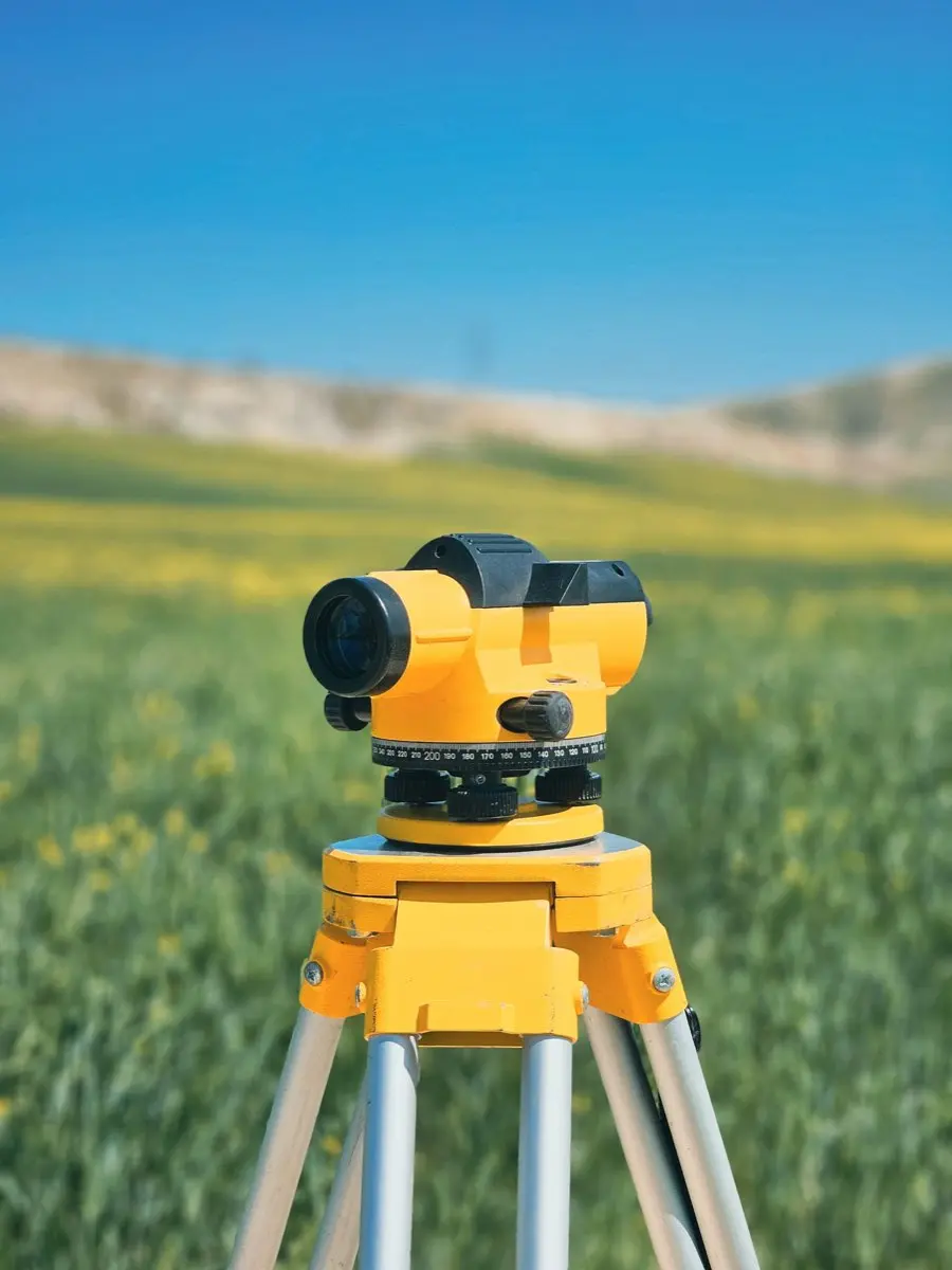 Niveau d'arpenteur installé dans un champ pour un relevé de terrain